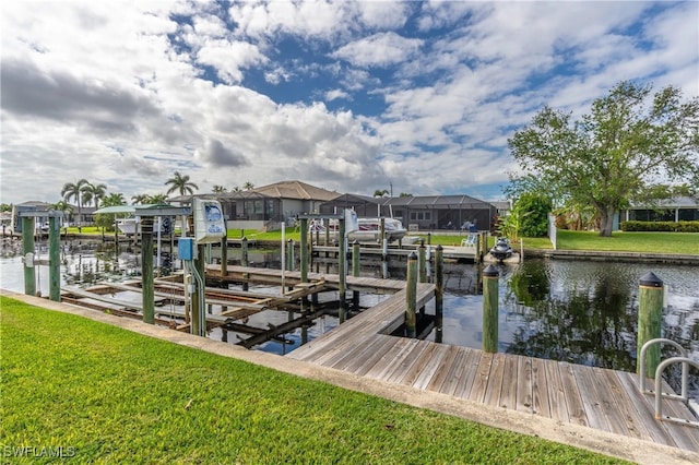 dock area with a lawn and a water view