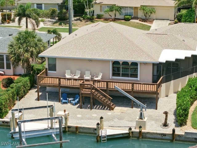 851 Perrine Ct, Marco Island, FL 34145 - rear view of property featuring roof with shingles, stucco siding, a wooden deck, and boat lift