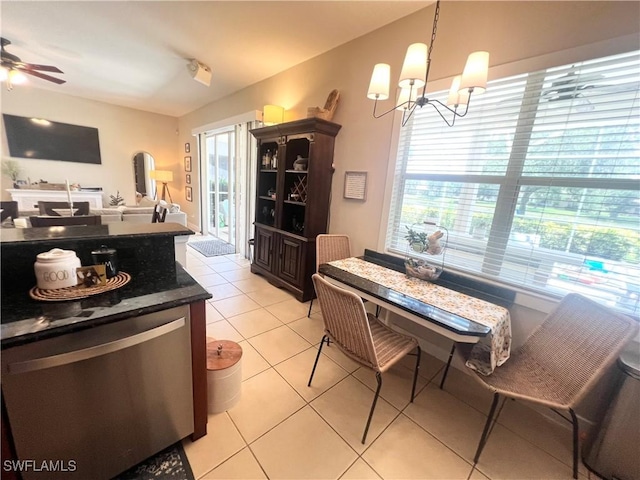 kitchen with stainless steel dishwasher, ceiling fan with notable chandelier, pendant lighting, light tile patterned floors, and fridge