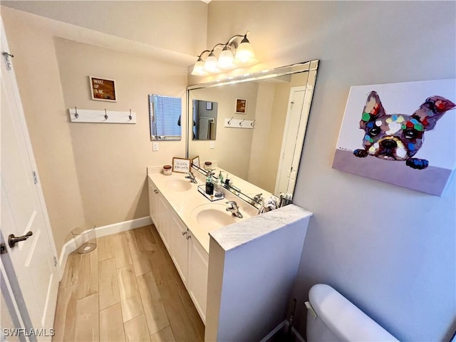 bathroom featuring vanity, wood-type flooring, and toilet