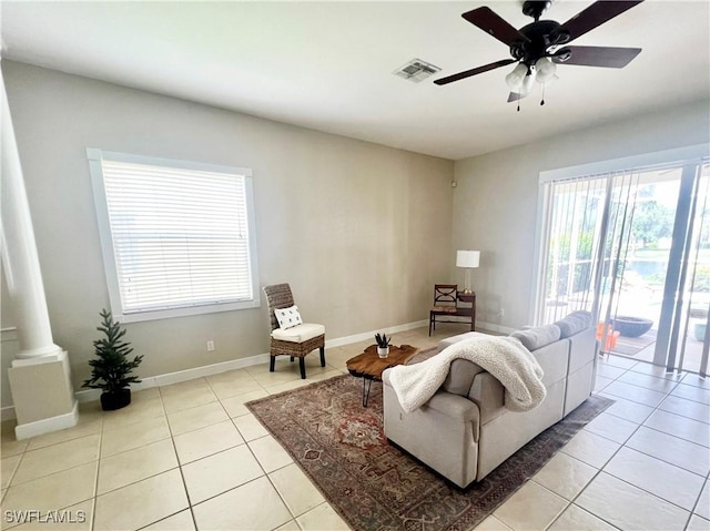 living room featuring decorative columns, ceiling fan, and light tile patterned flooring