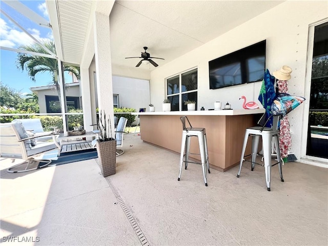 view of patio / terrace featuring ceiling fan and a bar