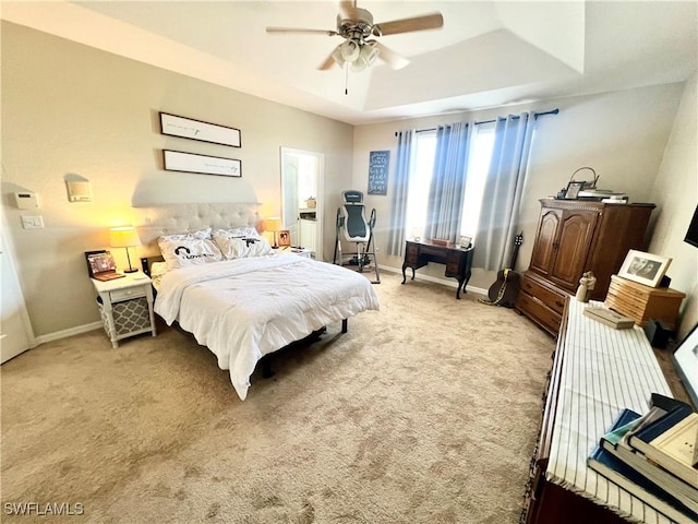 bedroom with light carpet, a raised ceiling, and ceiling fan