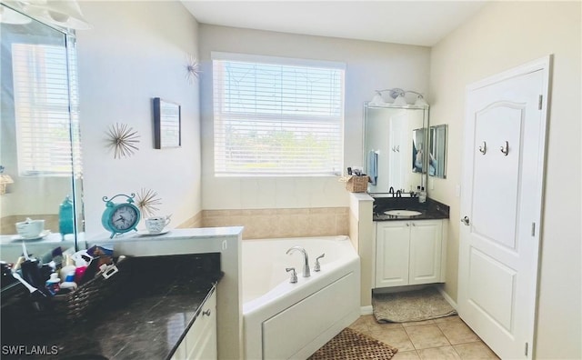 bathroom featuring tile patterned flooring, vanity, a bathing tub, and a healthy amount of sunlight