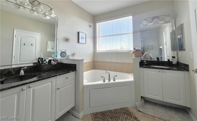 bathroom featuring tile patterned flooring, vanity, and a tub to relax in