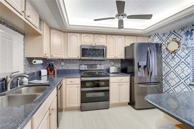 kitchen featuring sink, backsplash, appliances with stainless steel finishes, and a raised ceiling