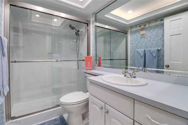 bathroom with toilet, a shower with door, and vanity