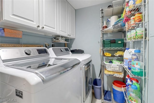 laundry room with washing machine and dryer and cabinets