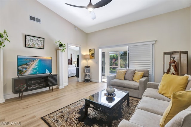 living room featuring ceiling fan, light hardwood / wood-style floors, and lofted ceiling