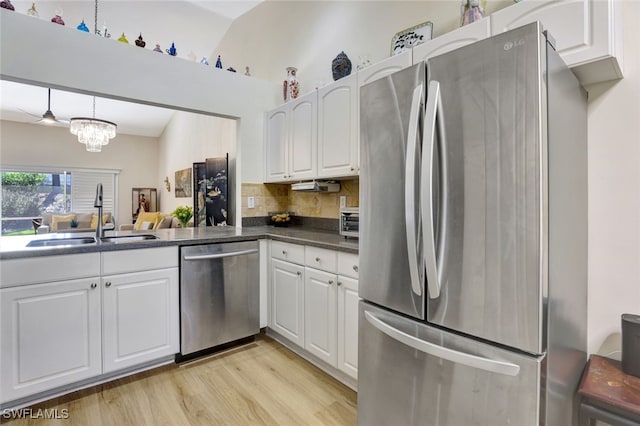 kitchen with decorative backsplash, stainless steel appliances, sink, a notable chandelier, and white cabinetry