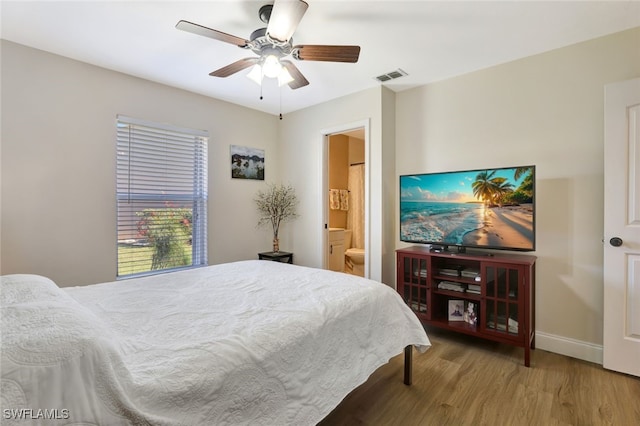 bedroom featuring hardwood / wood-style flooring, ceiling fan, and connected bathroom