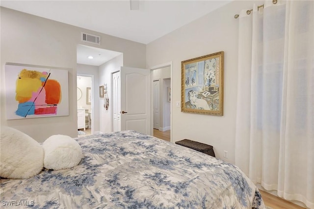 bedroom with ceiling fan, ensuite bath, and light hardwood / wood-style floors