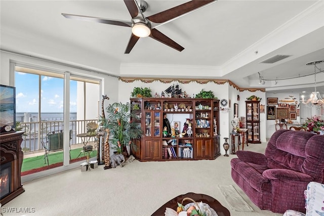 carpeted living room with a water view, ceiling fan, and ornamental molding