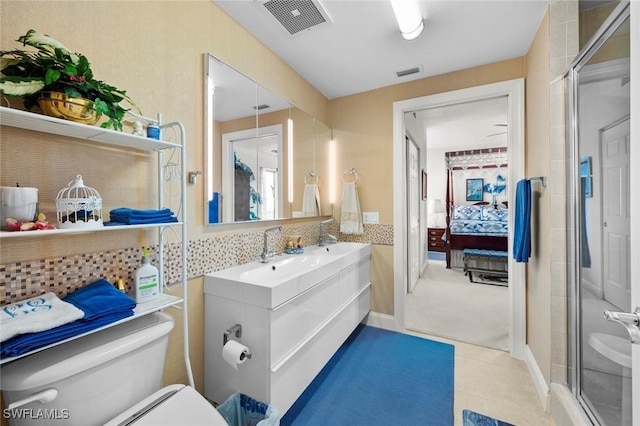 bathroom with backsplash, tile patterned floors, vanity, toilet, and a shower with shower door