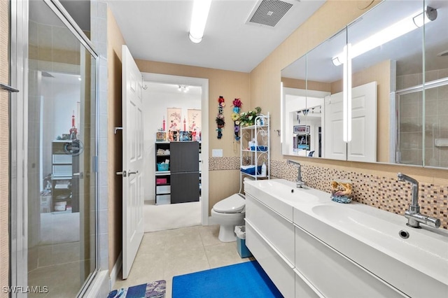 bathroom with tasteful backsplash, tile patterned floors, vanity, a shower with door, and toilet