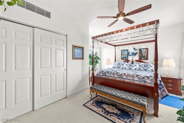 bedroom with ceiling fan, light colored carpet, and a closet