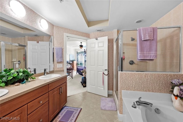 bathroom with separate shower and tub, a raised ceiling, ceiling fan, and vanity