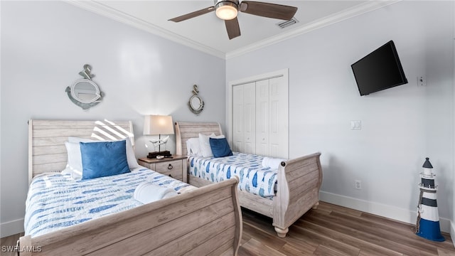 bedroom featuring dark wood-type flooring, a closet, ceiling fan, and ornamental molding