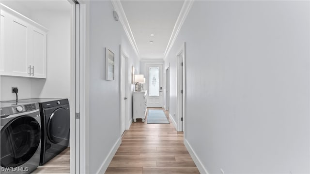 washroom featuring washer and dryer, light hardwood / wood-style floors, cabinets, and crown molding