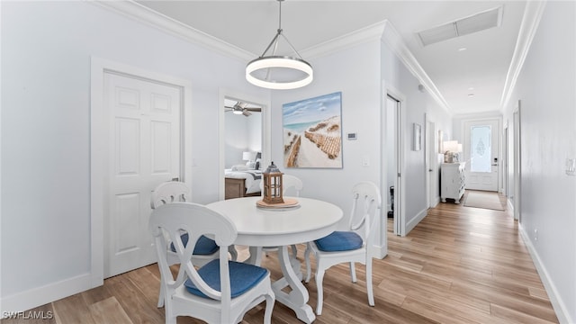 dining room featuring ceiling fan, crown molding, and light wood-type flooring