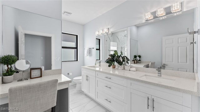 bathroom with vanity, toilet, and a shower