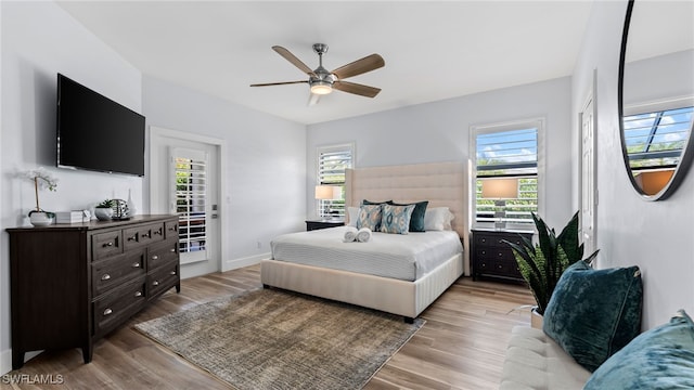 bedroom featuring multiple windows, ceiling fan, and light wood-type flooring