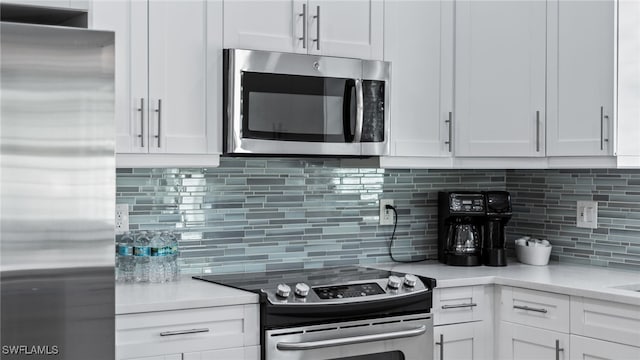 kitchen featuring backsplash, stainless steel appliances, and white cabinetry