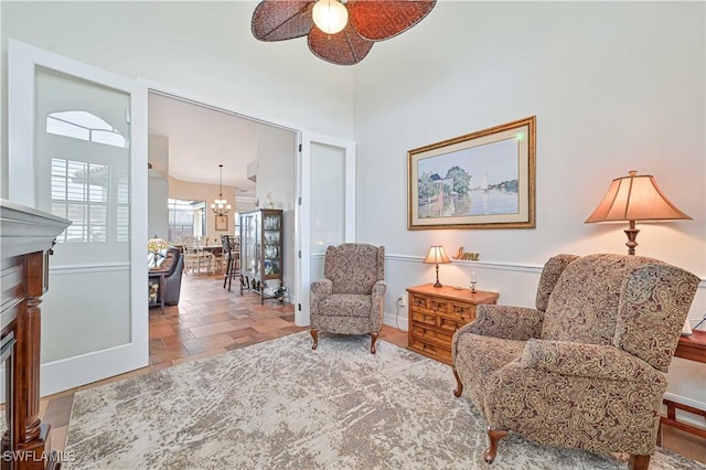 sitting room featuring ceiling fan with notable chandelier