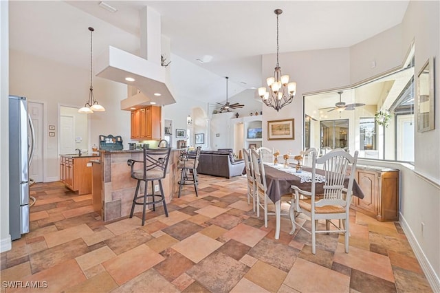 dining space with high vaulted ceiling and ceiling fan with notable chandelier