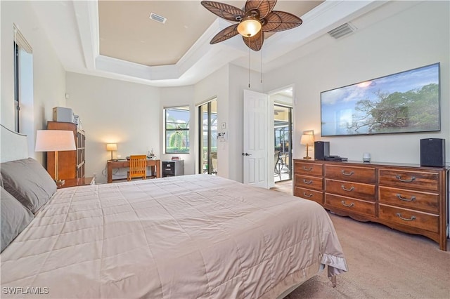 carpeted bedroom featuring ceiling fan, a raised ceiling, and access to exterior