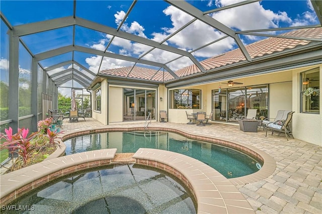 view of pool with glass enclosure, a patio area, ceiling fan, and an in ground hot tub