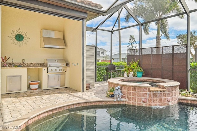 view of pool with an in ground hot tub, a patio, an outdoor kitchen, glass enclosure, and area for grilling