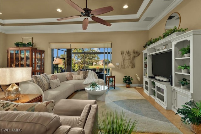 living room with a raised ceiling, ceiling fan, and ornamental molding