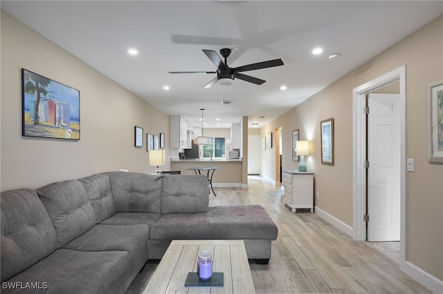 living room with light hardwood / wood-style floors and ceiling fan