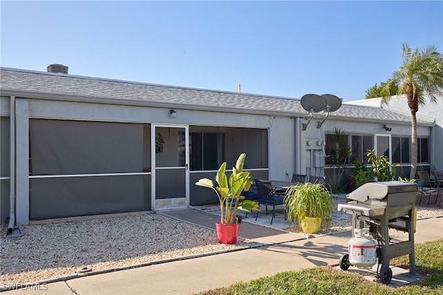 back of property with a sunroom and a patio area