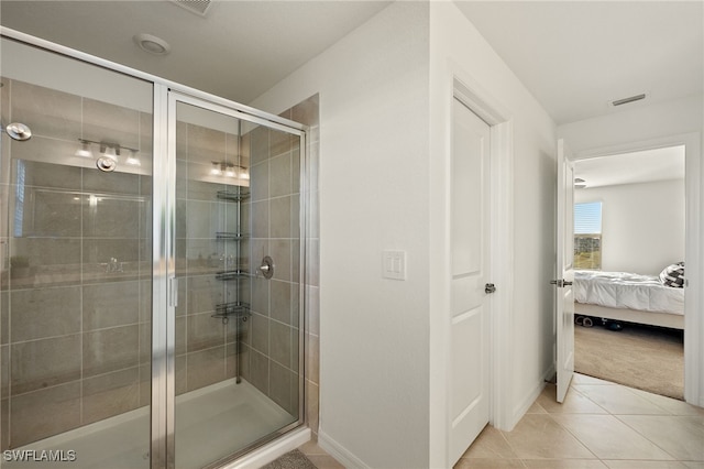 bathroom with tile patterned flooring and a shower with shower door