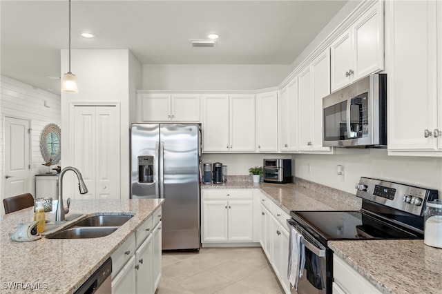 kitchen featuring white cabinets, sink, appliances with stainless steel finishes, decorative light fixtures, and light stone counters