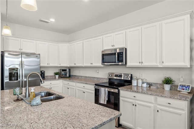 kitchen with white cabinetry, sink, stainless steel appliances, and decorative light fixtures