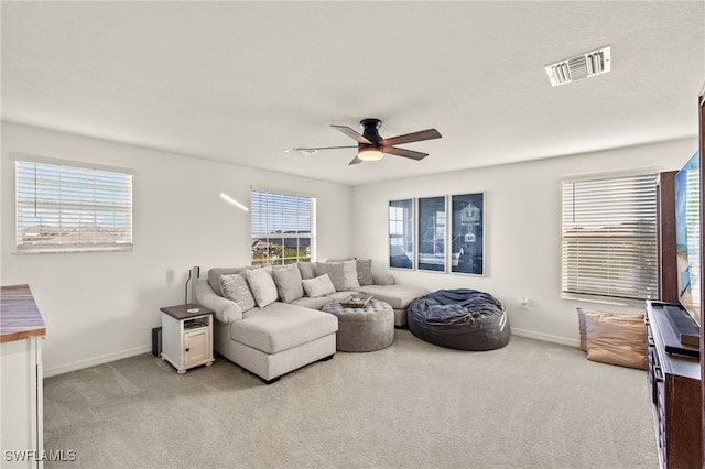 carpeted living room with ceiling fan