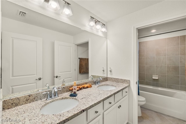 full bathroom featuring tile patterned flooring, vanity, toilet, and tiled shower / bath