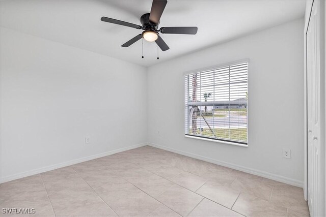 unfurnished room with ceiling fan and light tile patterned floors