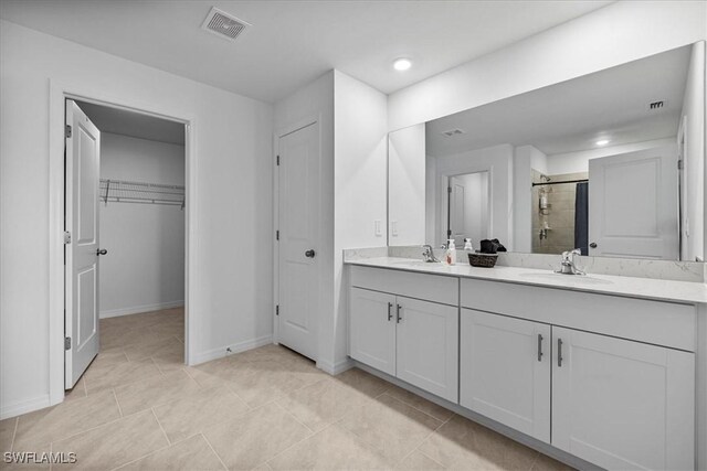 bathroom with tile patterned flooring, vanity, and a shower with door