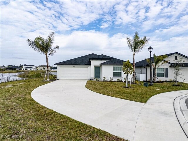 ranch-style home with a water view, a garage, and a front lawn