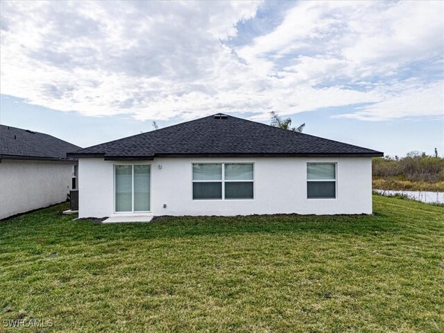 back of house with a yard and central AC