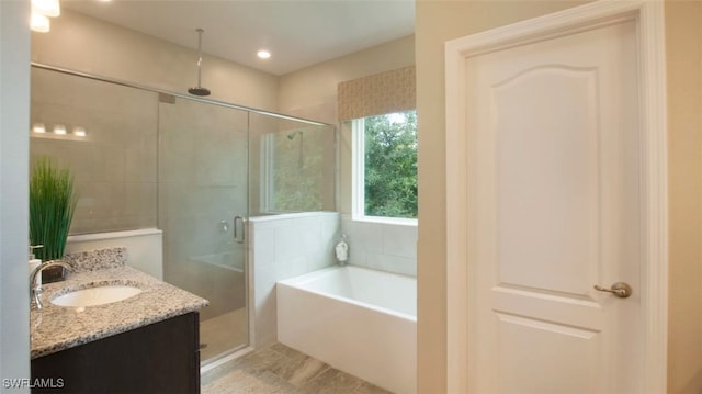 bathroom with tile patterned floors, vanity, and shower with separate bathtub