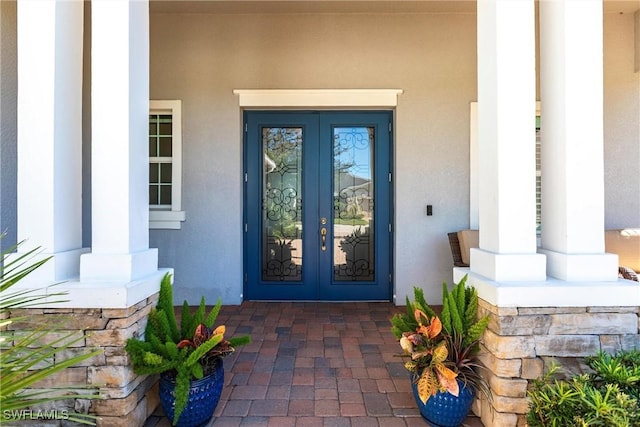 entrance to property featuring covered porch and french doors