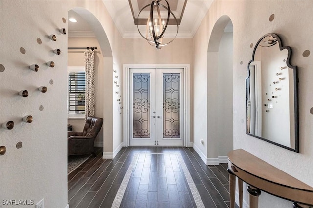 foyer featuring a notable chandelier, ornamental molding, and french doors