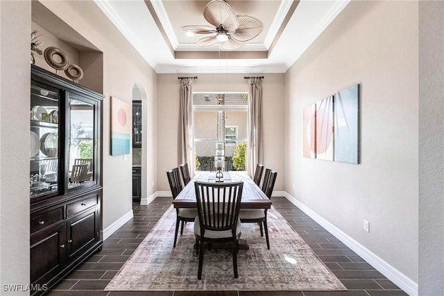 dining area with ceiling fan, a raised ceiling, and crown molding