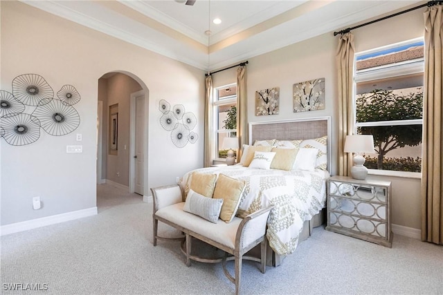 carpeted bedroom featuring a tray ceiling, ceiling fan, and crown molding