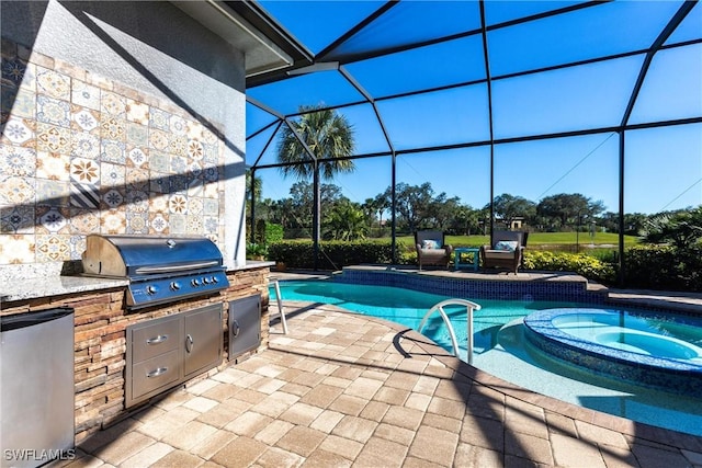 view of swimming pool featuring an outdoor kitchen, a grill, a lanai, and a patio